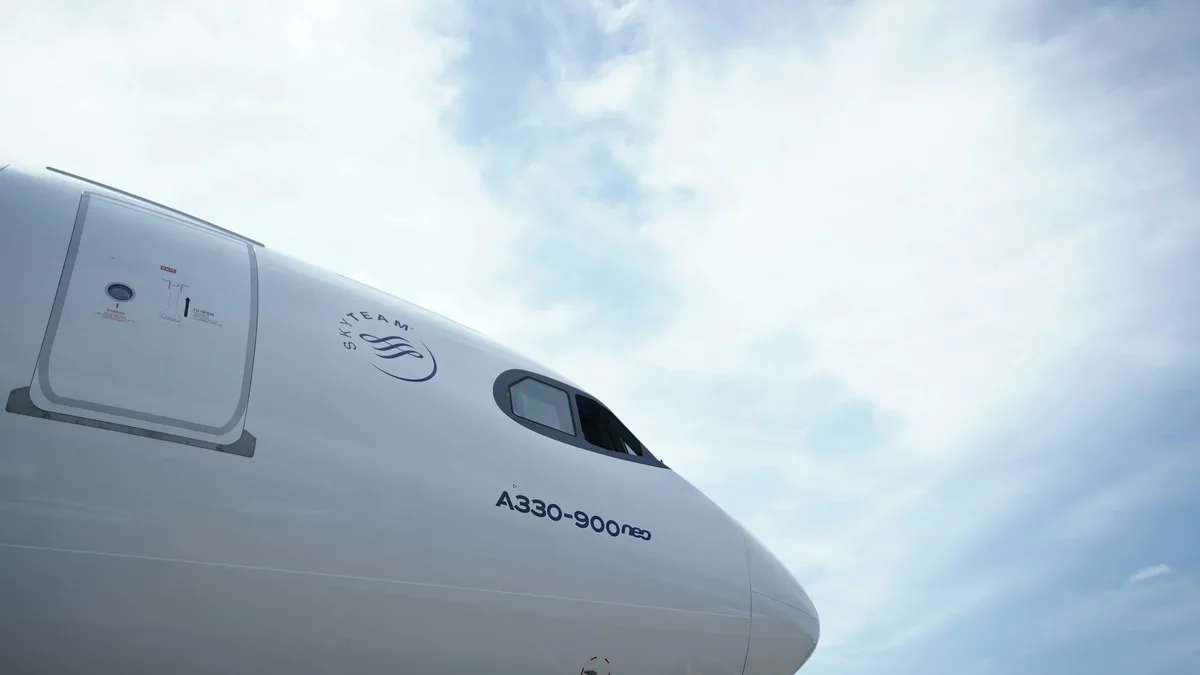 The nose of an Airbus A330-900neo aircraft, with the sky visible in the background.